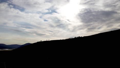 silhouette of people climbing a mountain