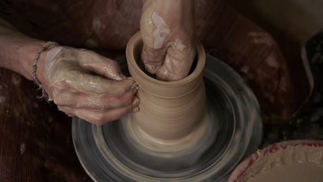 the potter makes a jug of clay. ceramist. a man makes a vase on a potter's wheel