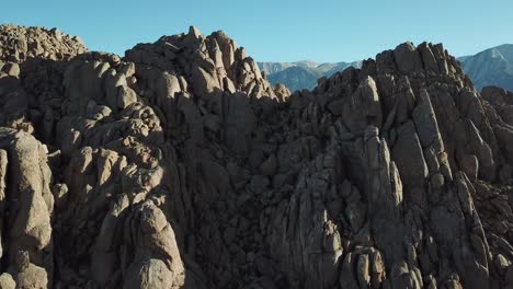 Tilt-Up-Aerial-View-on-Sandstone-Rock-Formations-in-American-Desert-Valley-Under-Alabama-Hills,-California