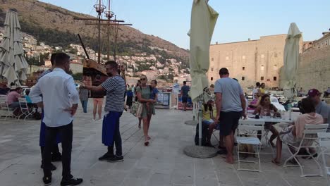 a bustling square in dubrovnik, croatia, filled with locals and tourists. historic charm meets lively atmosphere in this vibrant, picturesque destination.