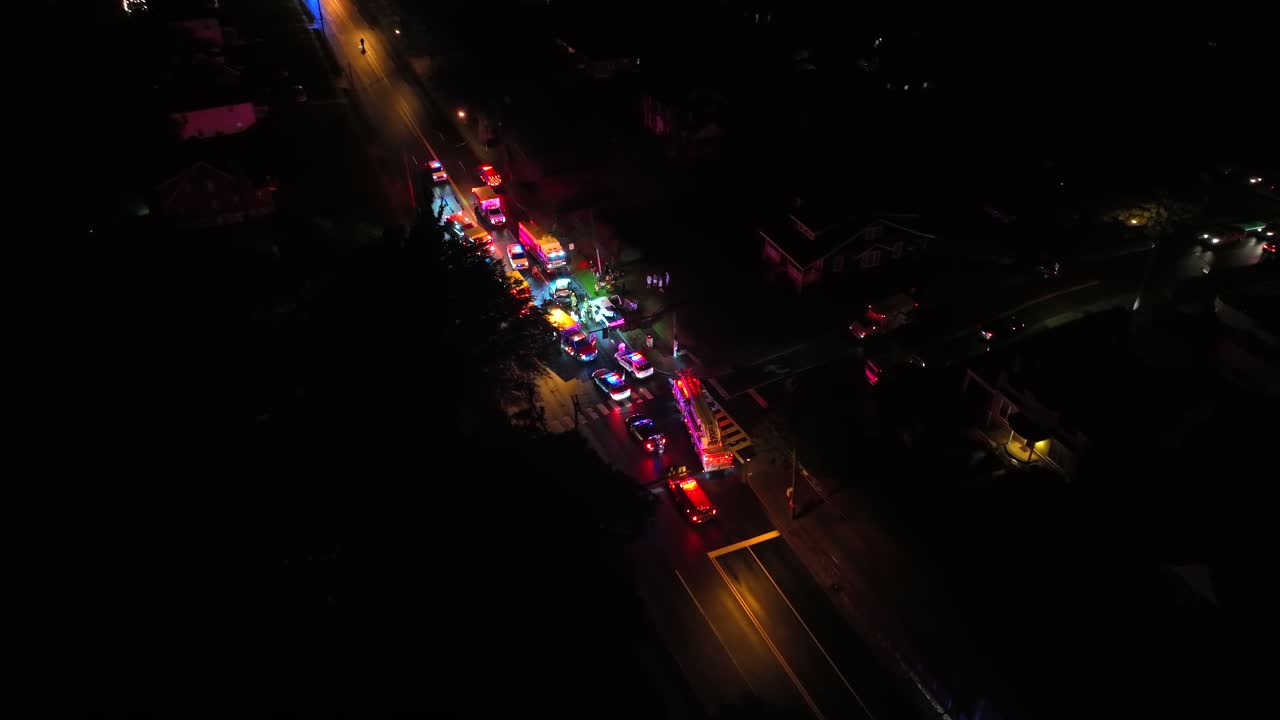 Emergency Response at Night: Aerial View of Firetrucks, Police, and Ambulances at Accident Scene