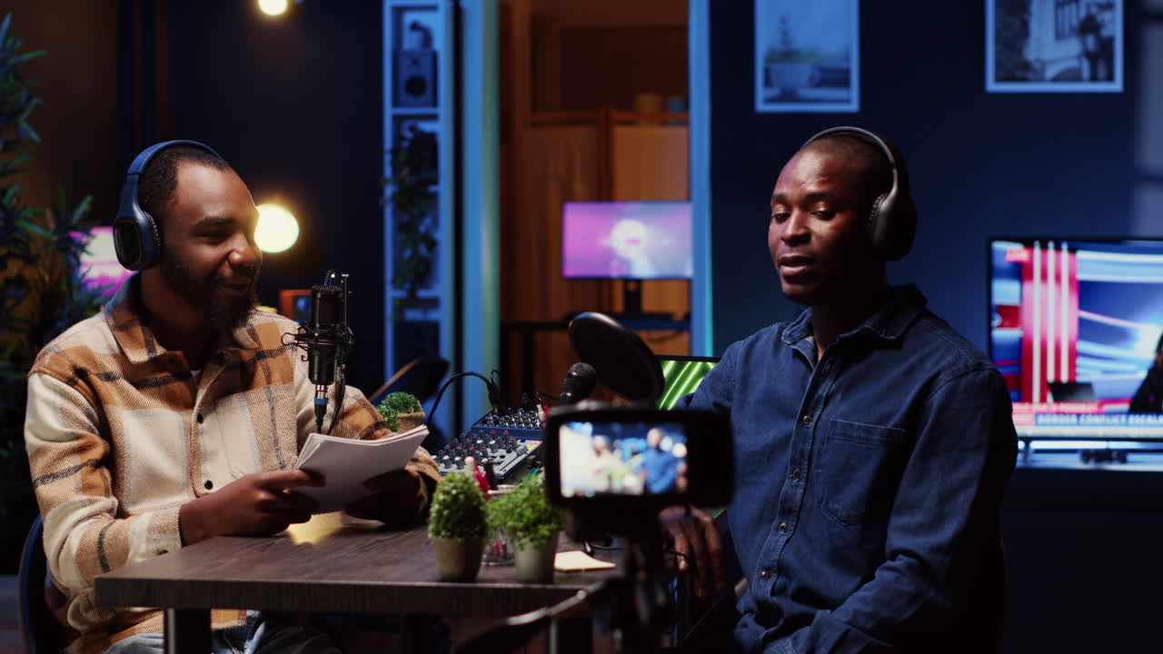 Internet show host making guest laugh, cracking jokes during comedy focused podcast