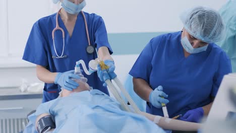 el anestesiólogo con guantes médicos prepara a la paciente femenina para la cirugía, coloca al paciente en anestesia, regula la máscara de oxígeno. la enfermera administra anestesia intravenosa, catéter intravenoso. cirugía. anestesia