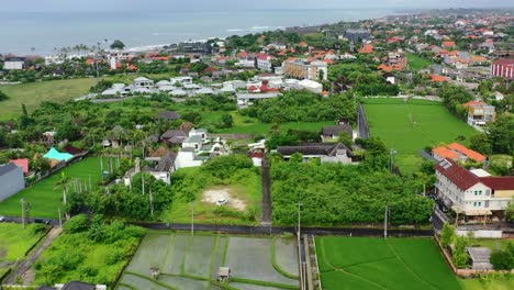 tropical green island coastline in canggu bali on cloudy day, aerial