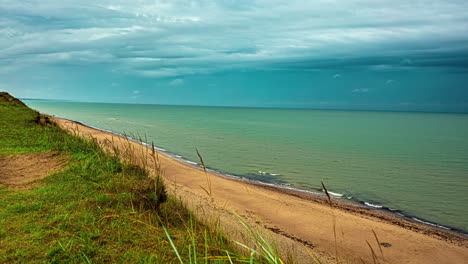 Timelapse-shot-of-dark-cloud-movement-over-the-shoreline-with-waves-crashing-on-the-beach-on-a-rainy-day