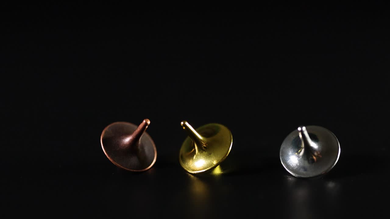 어두운 표면에서 회전하는 세 개의 꼭대기