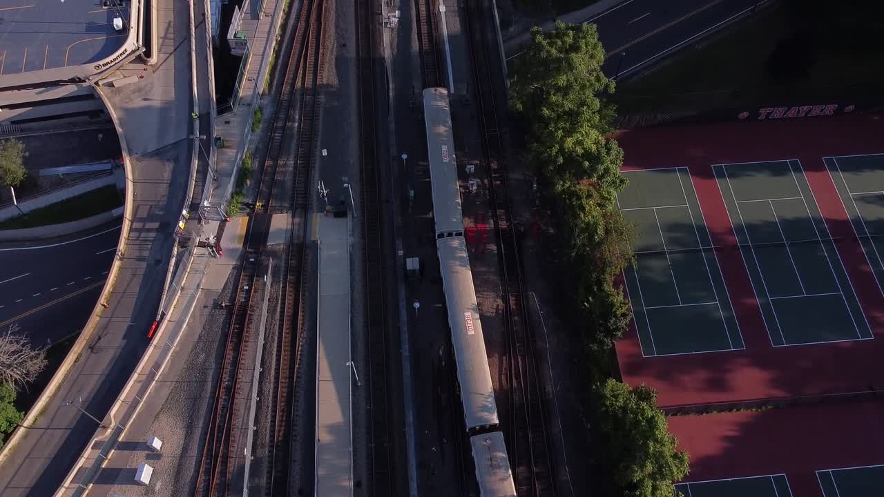 A MBTA red line train leaves a station near a tennis court