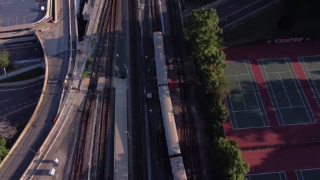 a mbta red line train leaves a station near a tennis court