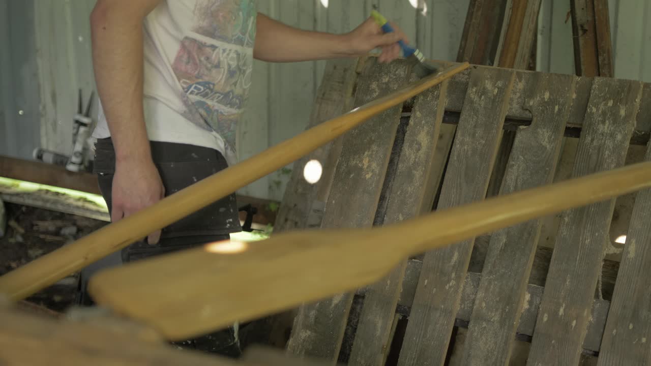 cepillando aceite danés en las palas de las canoas de pino