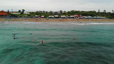 lugareños y turistas disfrutando de las olas en canggu, bali