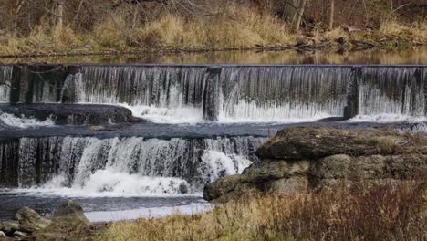 Fast-flowing-waterfall-cascading-down-multiple-levels-into-rocky-river-wilderness