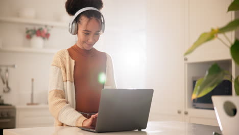 headphones, laptop and woman typing in home