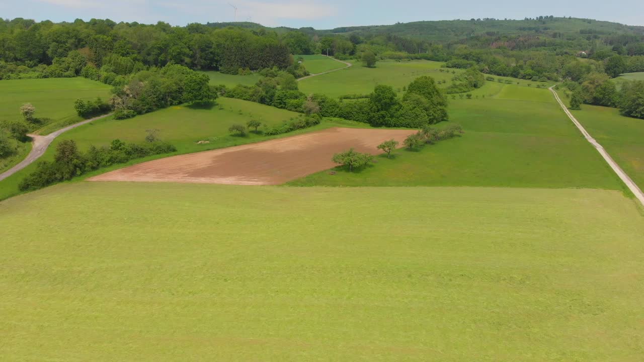 시골 시골의 들판이 있는 구불구불한 언덕 위를 날다
