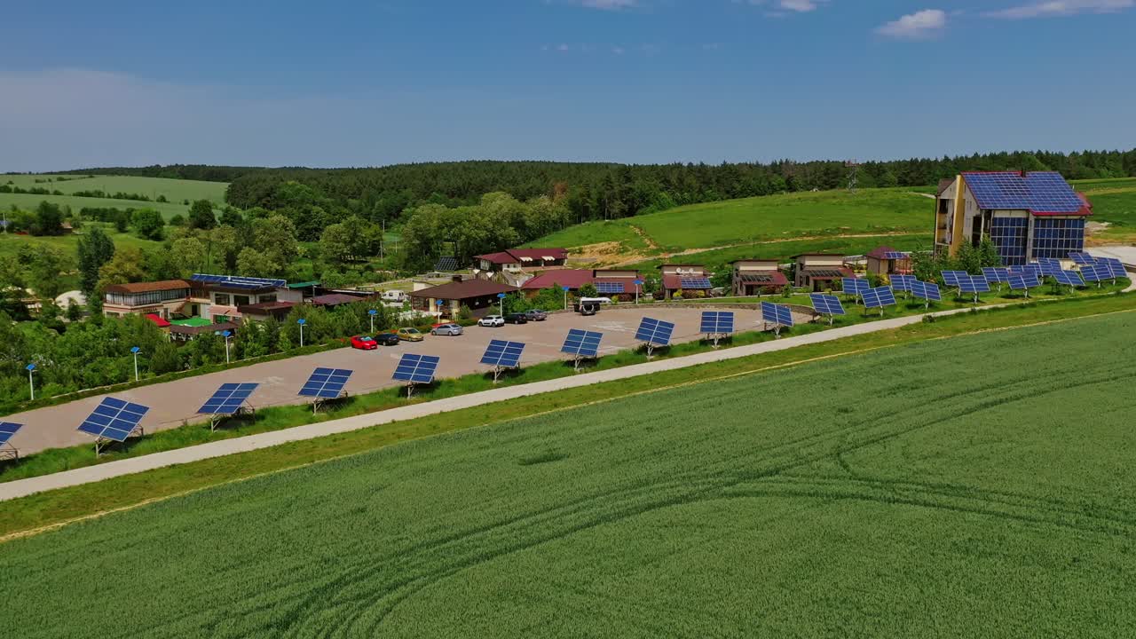 Modern complex with photovoltaic cells. Row of solar panels along the road in nature landscape. Sustainable energy. Aerial view.
