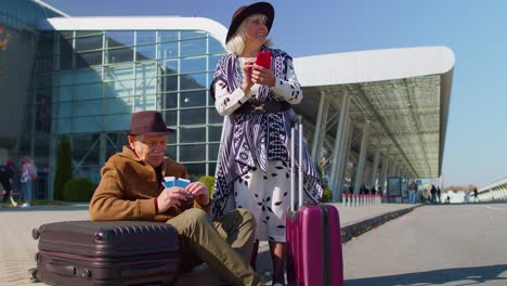 senior pensioner tourists grandmother grandfather waiting boarding near international airport hall