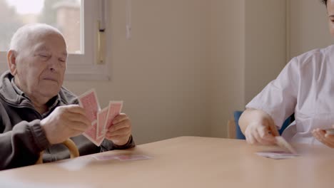 Senior man sorting cards ready to play in a geriatric