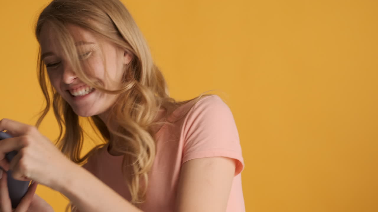 una mujer caucásica jugando videojuegos en su teléfono inteligente.