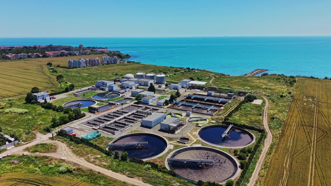 Industrial water treatment facility near coastline on a sunny day