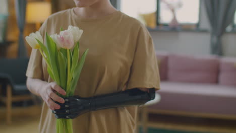 girl with prosthetic arm holding bouquet of flowers