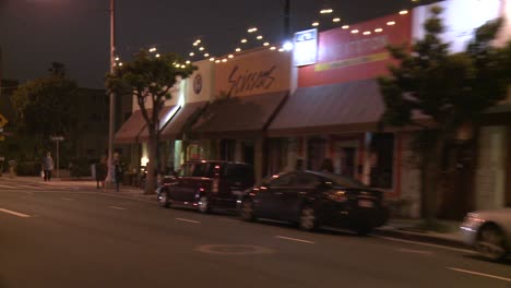 A-Car-Travels-Along-A-Street-At-Night-In-Santa-Monica-California-As-Seen-Through-The-Rear-Window-At-An-Angle