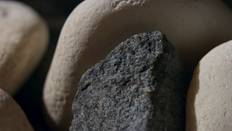 throwing water on hot stones in the sauna stove, medium shot of water splashing and evaporating into steam, heating the sauna