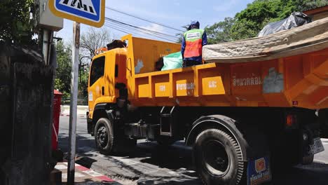 workers operating a garbage truck in the city