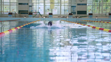 female swimmer swimming breaststroke in the indoor lap pool, front view