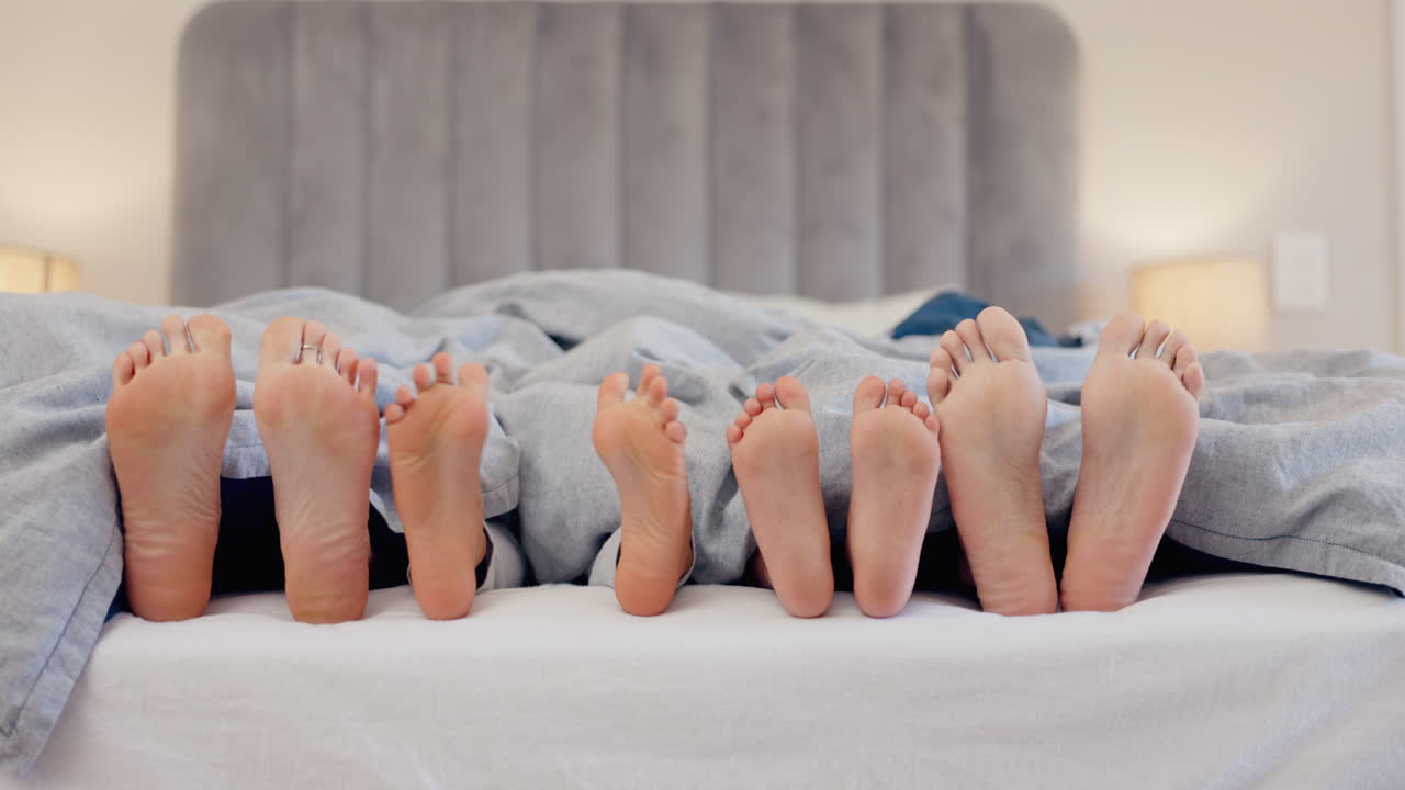 durmiendo, los pies y la familia se despiertan en una cama