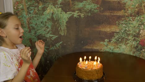 funny girl can not blow birthday candles on cake. joke party at home. young girl blowing candles on cake. lot of smoke and ash on table. fast motion effect. girl clapping.