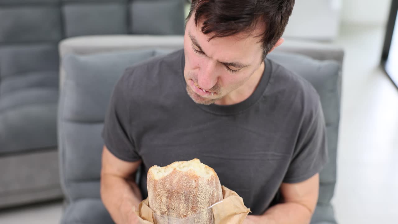 Man eating a large loaf of bread