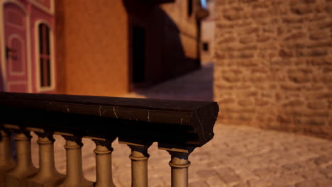 a stone railing overlooking a narrow cobblestone street in an old town