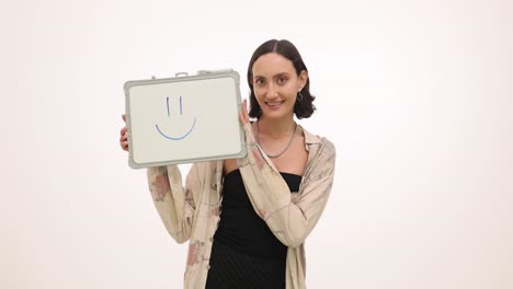 young woman holding a whiteboard with a smiley face