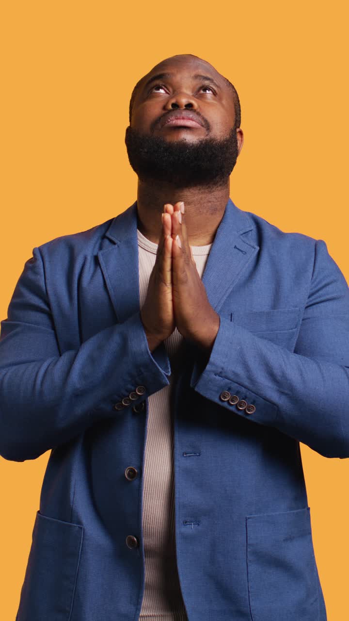 African American Man Praying with Hands Together Looking Up