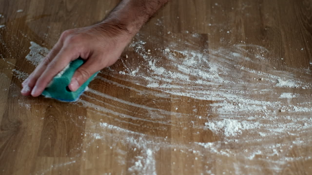 Efficient Scrubbing: Man Cleans Wooden Table with Suds