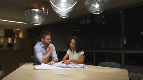 young office executives discussing over plans in a modern office