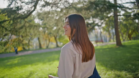 smiling woman exploring park walking at sunlight closeup. casual sunny stroll