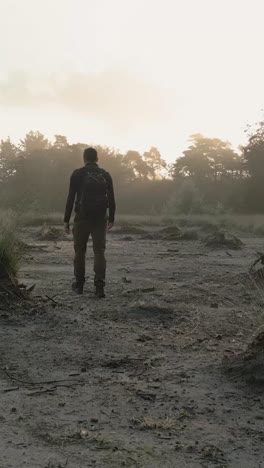 person hiking in misty morning forest