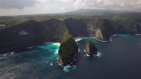 drone volando sobre la playa de kelingking en la isla de nusa penida sobre la costa del mar península verde horizonte de arena amarilla revelar