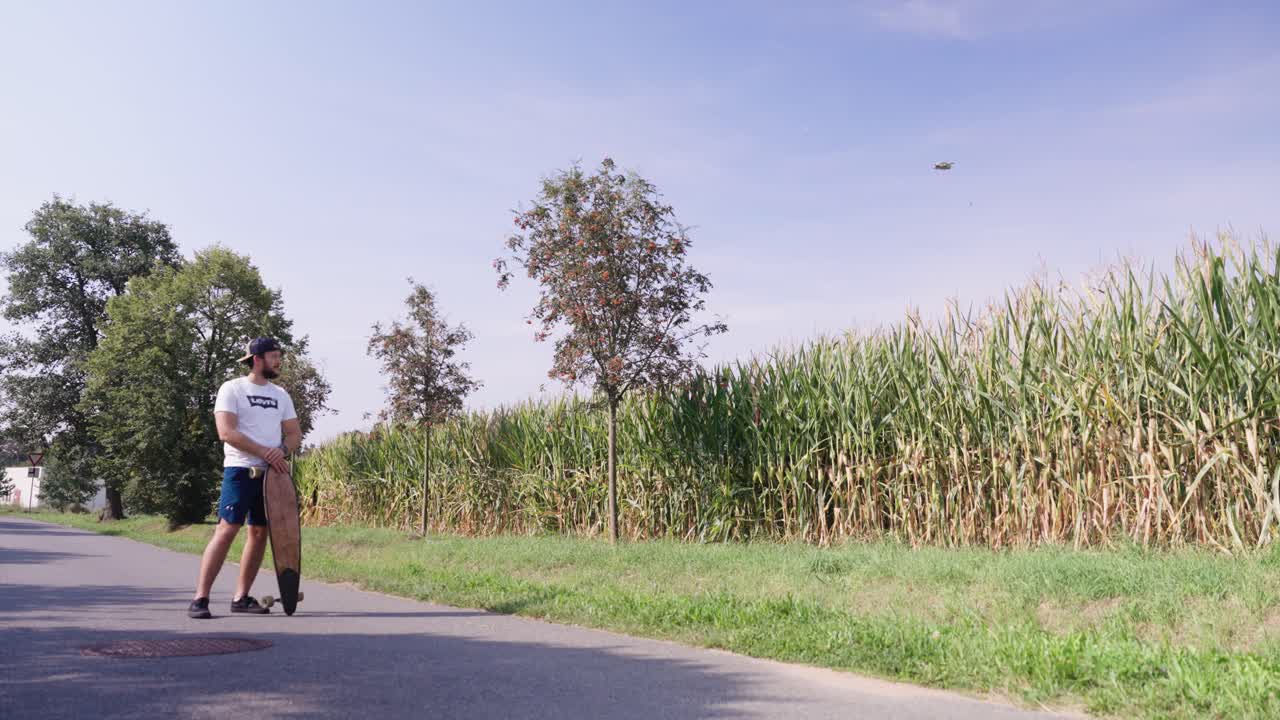 Man with Longboard in Cornfield