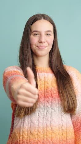 smiling woman giving thumbs up in positive gesture