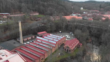 Aerial-view-of-Jonsered's-factories-industrial-community-belted-by-trees,-Sweden