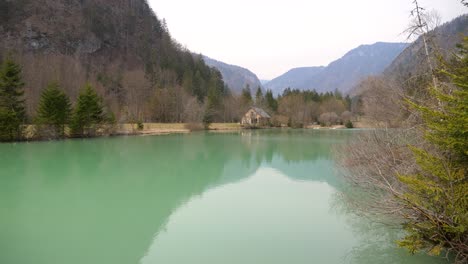 static shot of a small house on the shore of a private tropical lake in slovenia