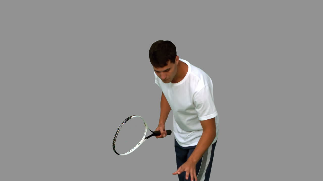 회색 스크린에서 테니스 공과 라켓을 들고 있는 남자