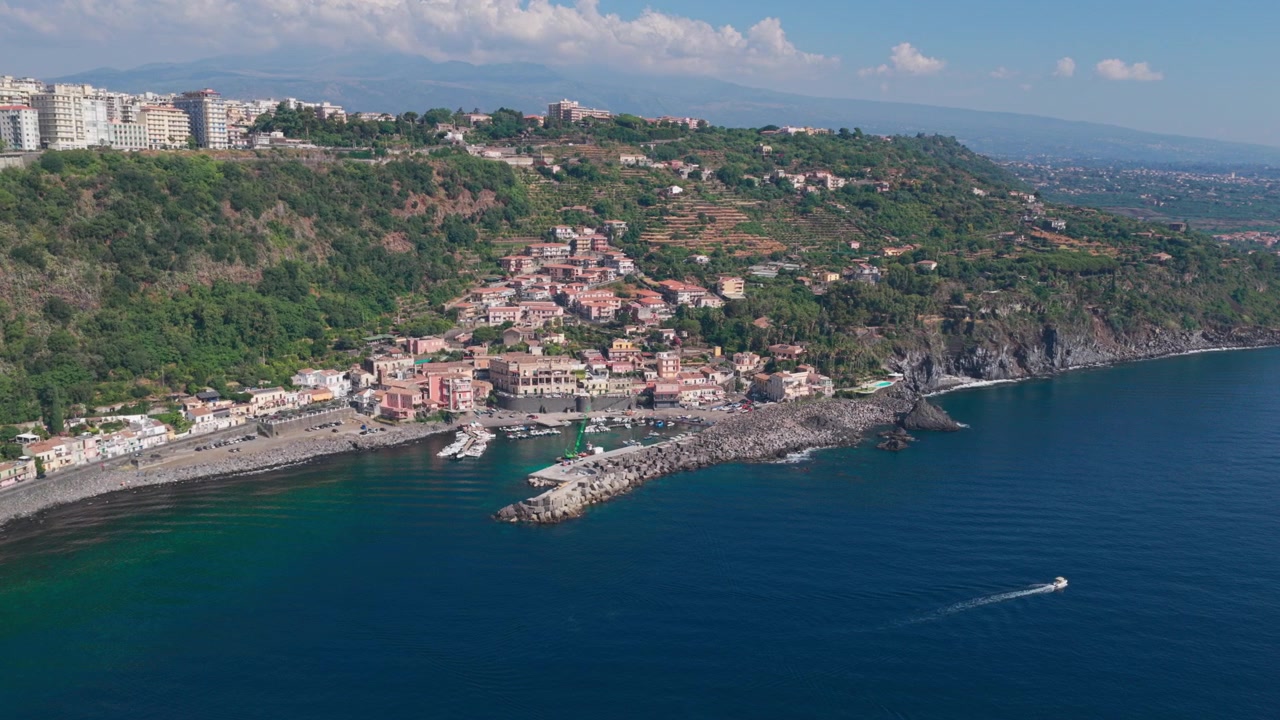 Ripresa aerea con drone di Santa Maria la Scala, un villaggio di pescatori circondato da scogliere di lava basaltica nera vicino all'Etna ad Acireale, Catania, Sicilia, Italia, una destinazione popolare sulla costa ionica