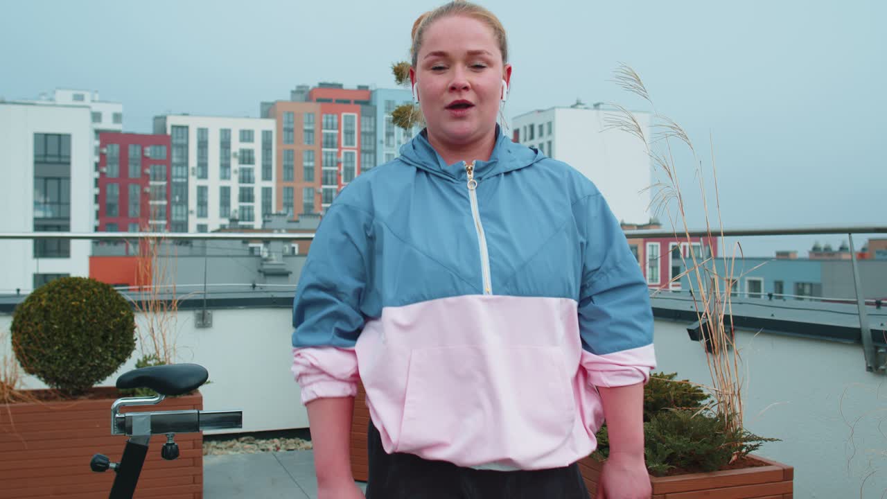 Sport fit woman in sportswear exercise kicking punching high leg kick on roof of house aerobic