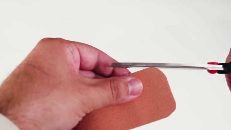 Kinesiology medical taping, doctor Physical therapist applying elastic surgical tape to patient body, treating injured knee young athlete.Post traumatic rehabilitation, sport physical therapy recovery