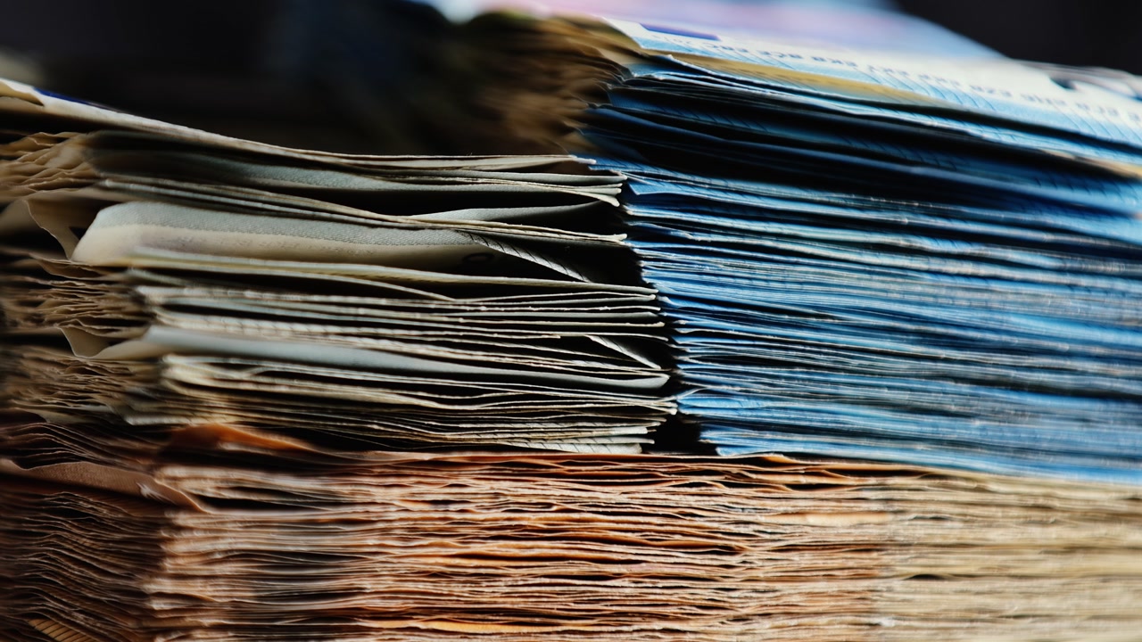 Abstract close-up of euro stacks partially hidden in shadow, evoking secrecy