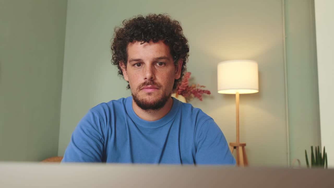 Man with curly hair wearing a blue shirt
