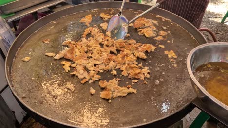 stirring and frying rice on outdoor wok.