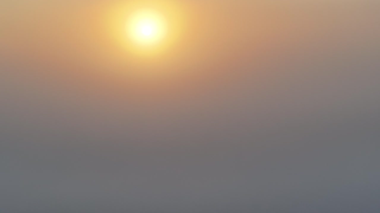 vista dorada del amanecer del avión no tripulado mientras asciende de la niebla matutina